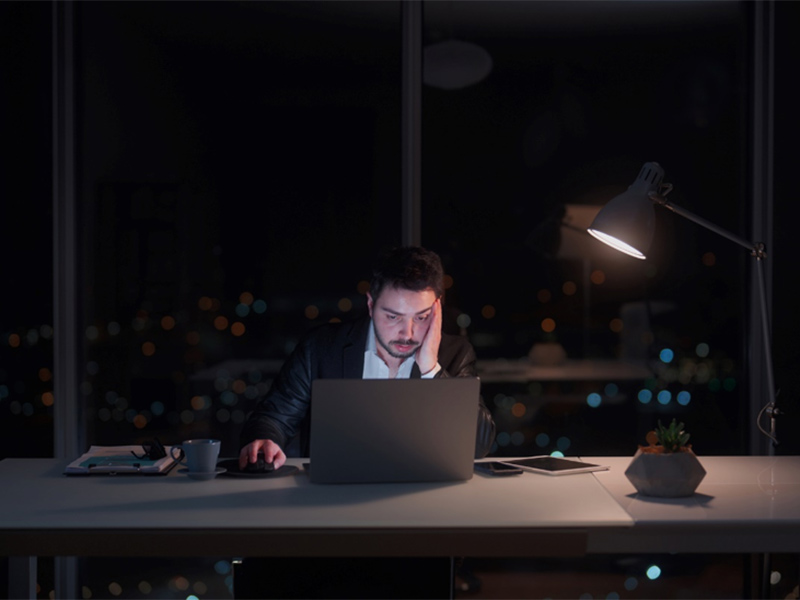 Person working on laptop at night desk